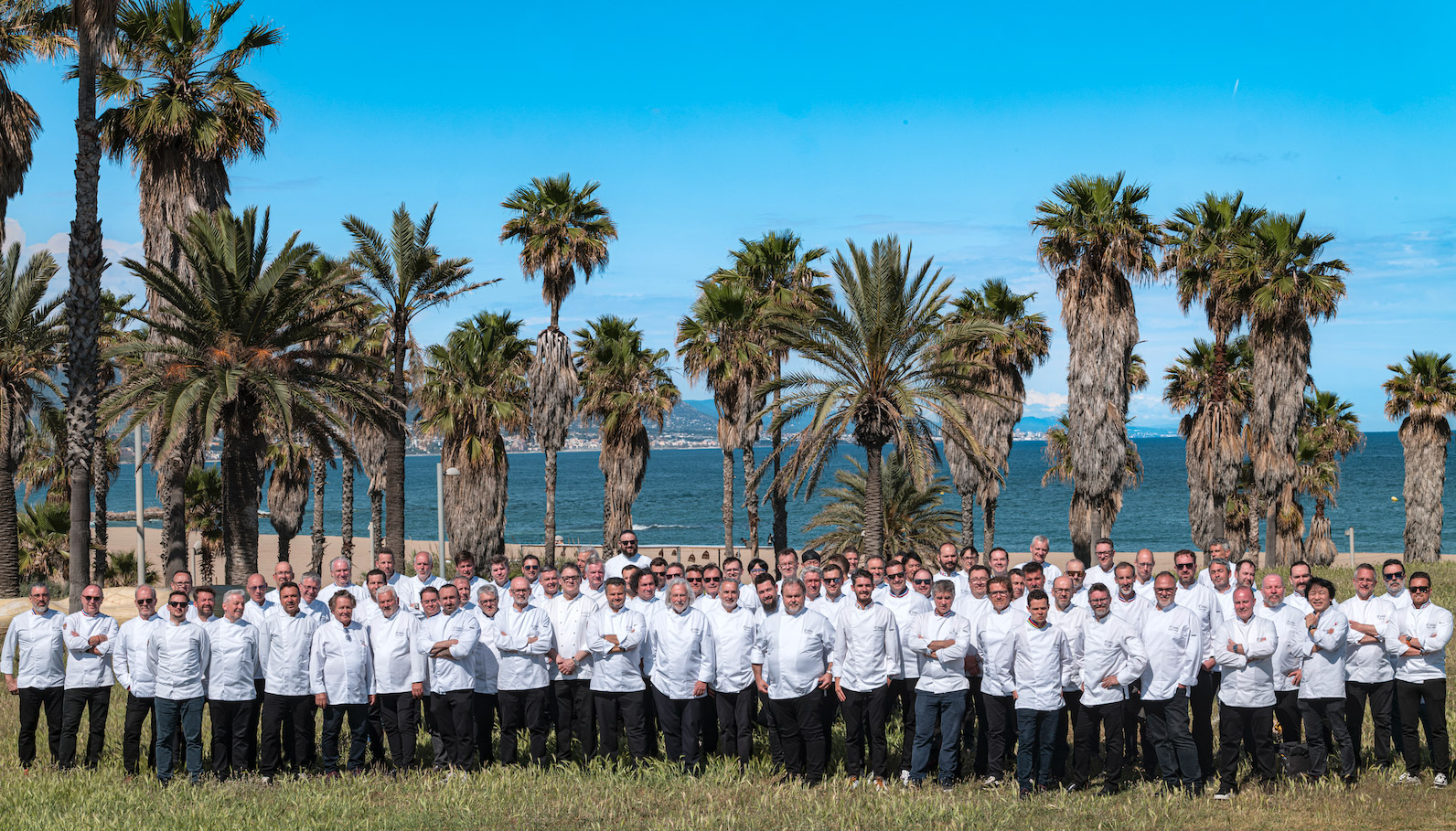 Photo de groupe des membres Relais Desserts International réunis en bord de mer lors du congrès