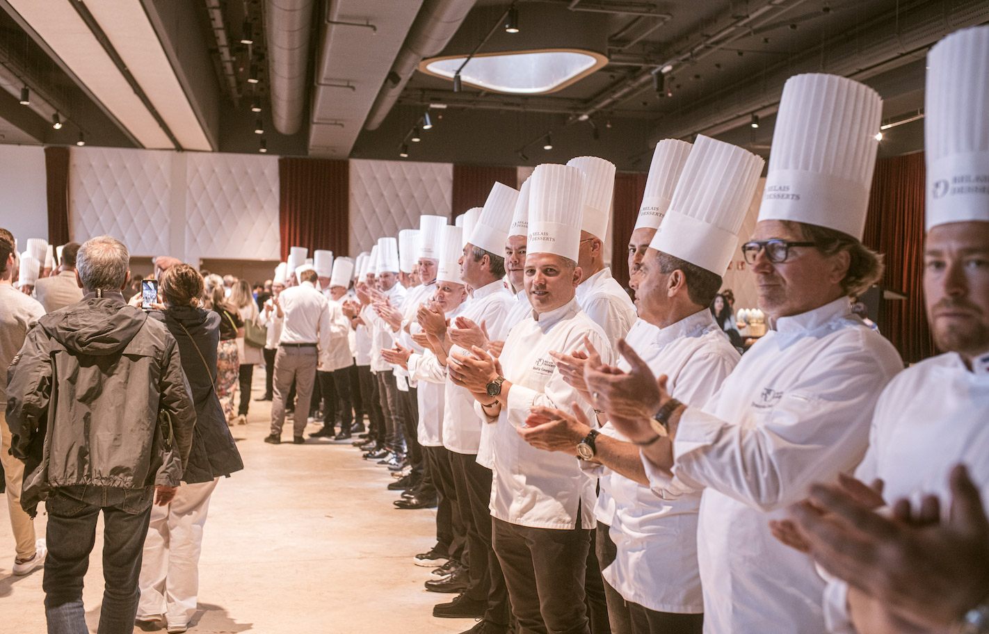 Rangée de chefs pâtissiers Relais Desserts en toque applaudissant lors de la cérémonie de clôture du congrès